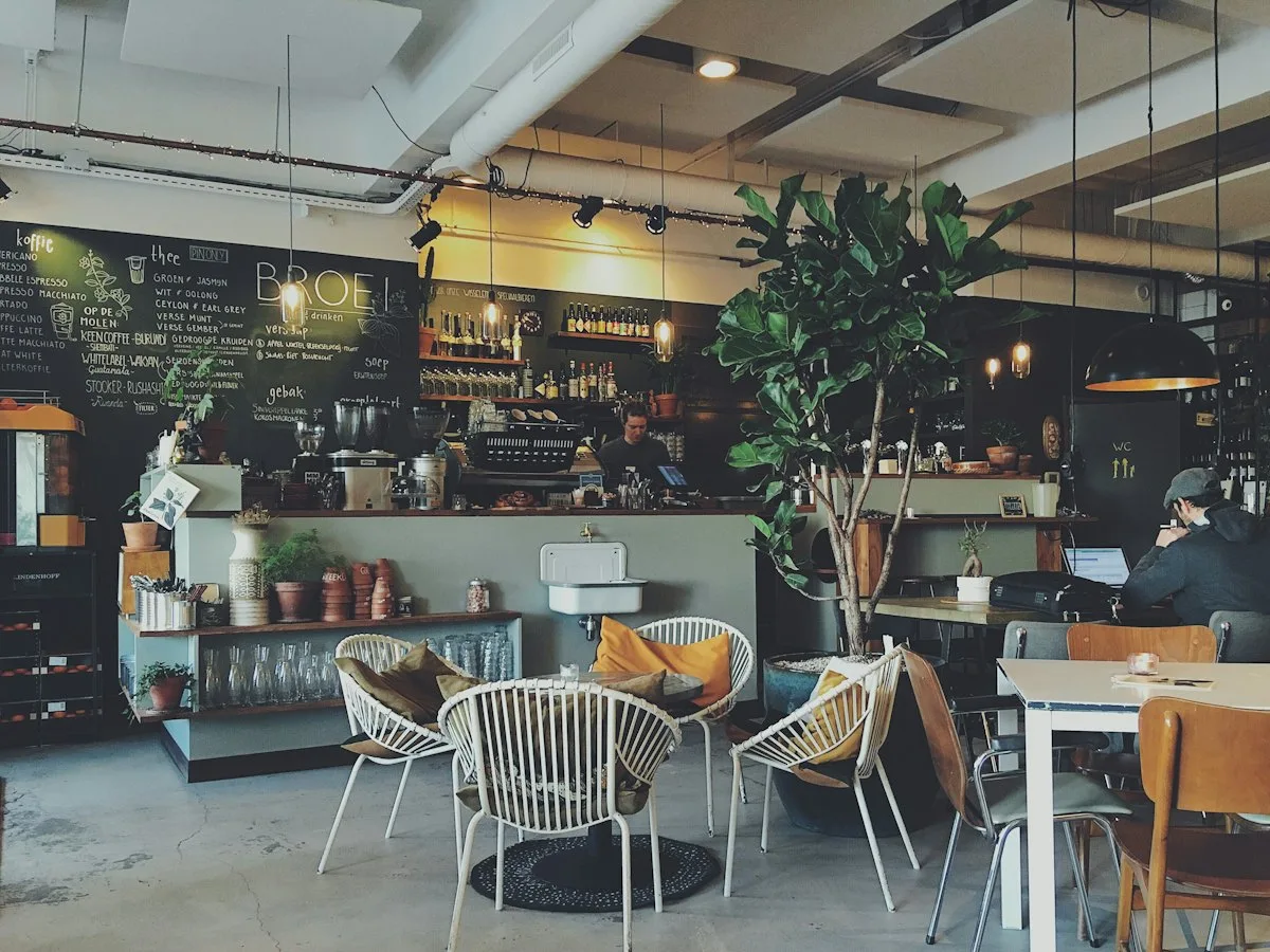 Jasne wnętrze bistro z ladą i stolikami