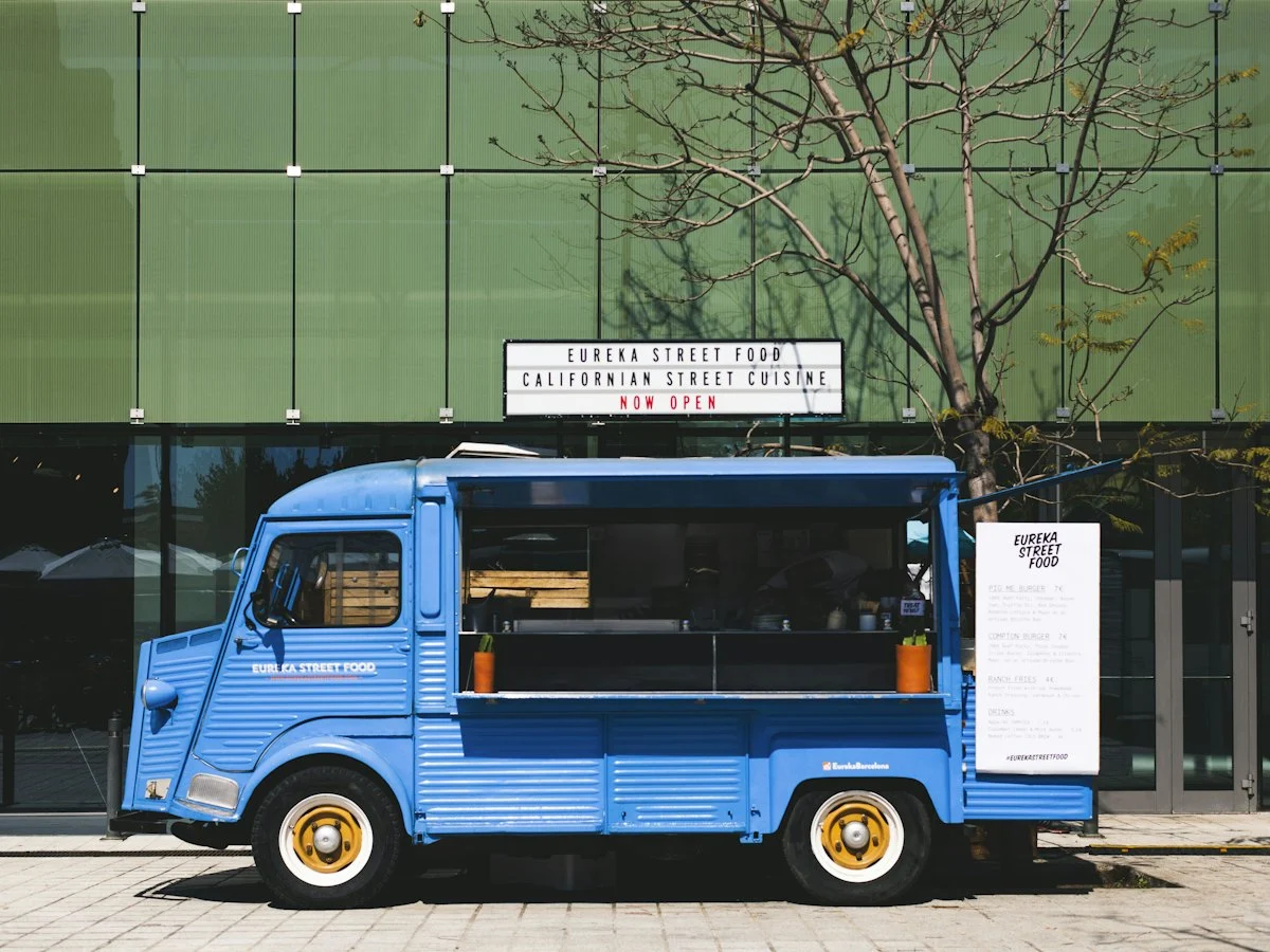 A food truck on a square with its serving hatch open