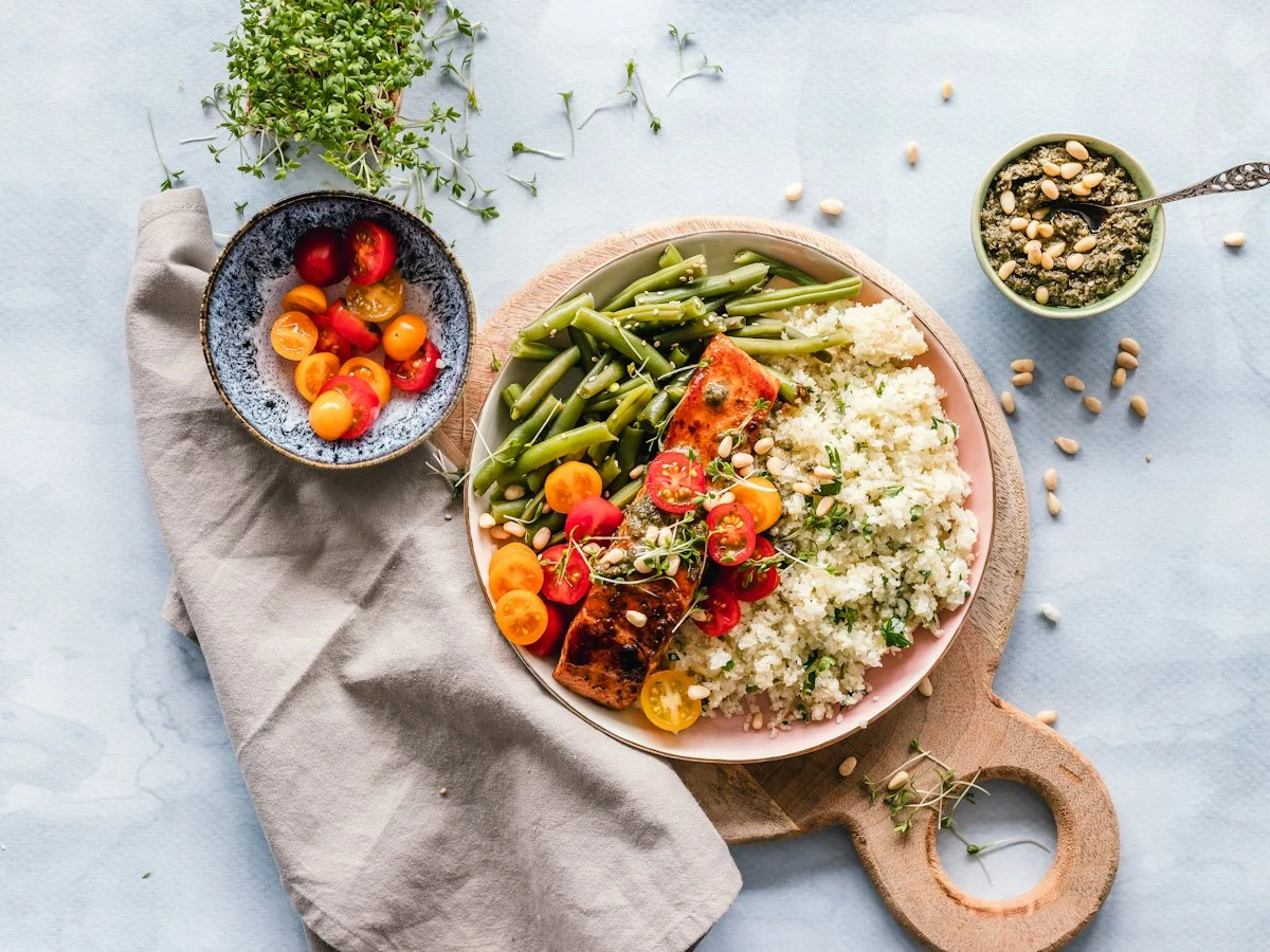 A plate of salmon, green beans and buckwheat on a wooden board